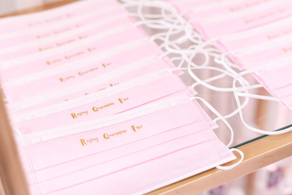 Pink face masks with resting quaratntine face in gold letters for a bridal shower during covid.