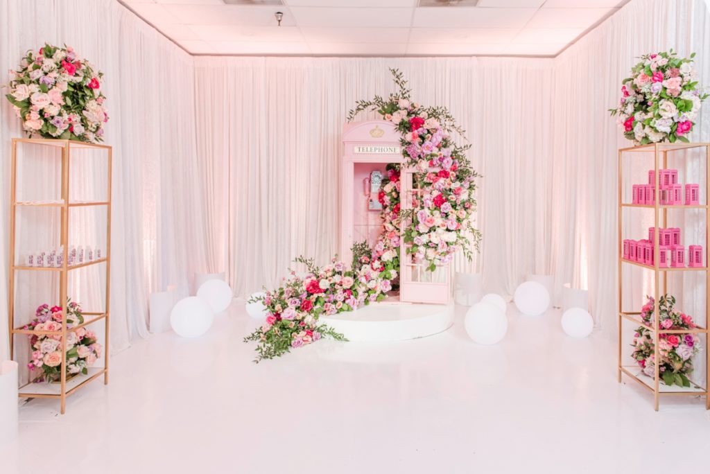 Pink flower covered telephone booth photo backdrop for a luxury bridal shower