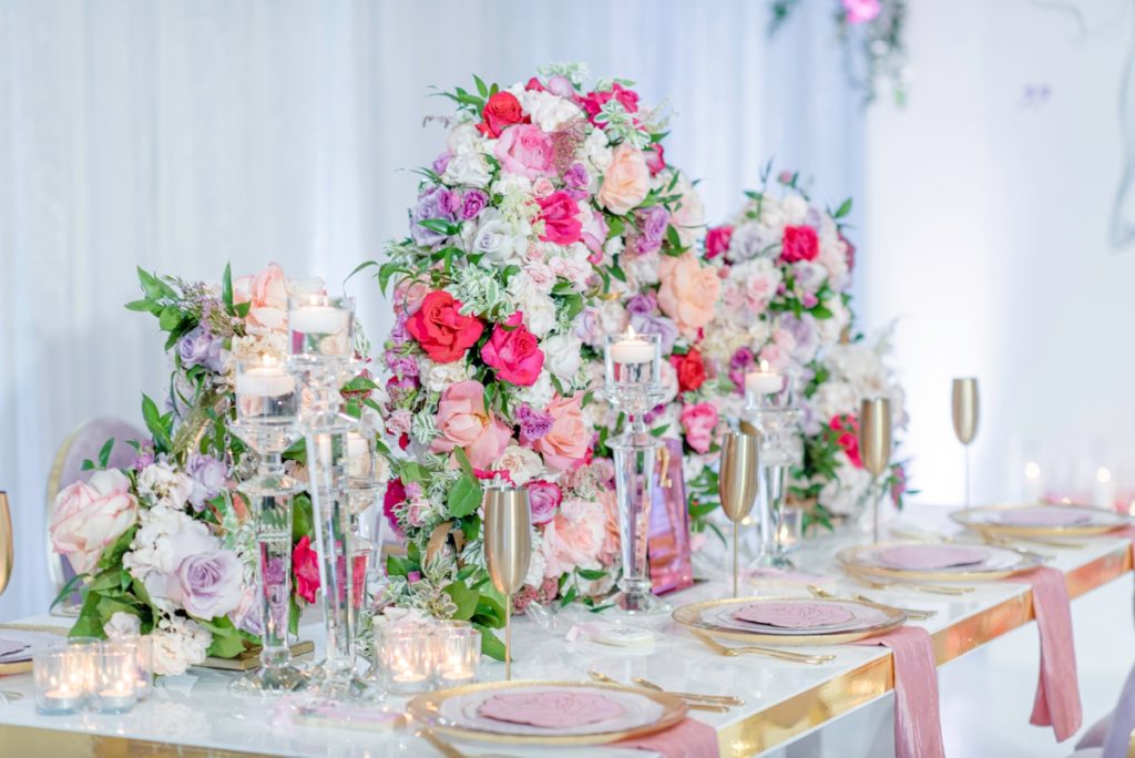 Circular floral centerpieces used on a luxury wedding shower tablescape.