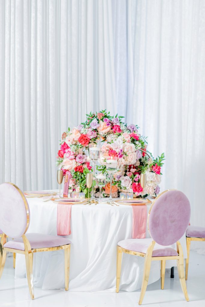 Unique flower centerpieces using white, pink and purple roses.