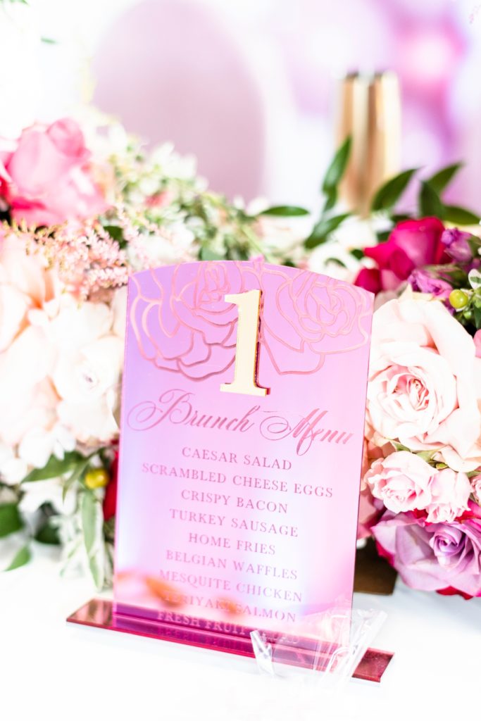 Pink acrylic table numbers that include a brunch menu.