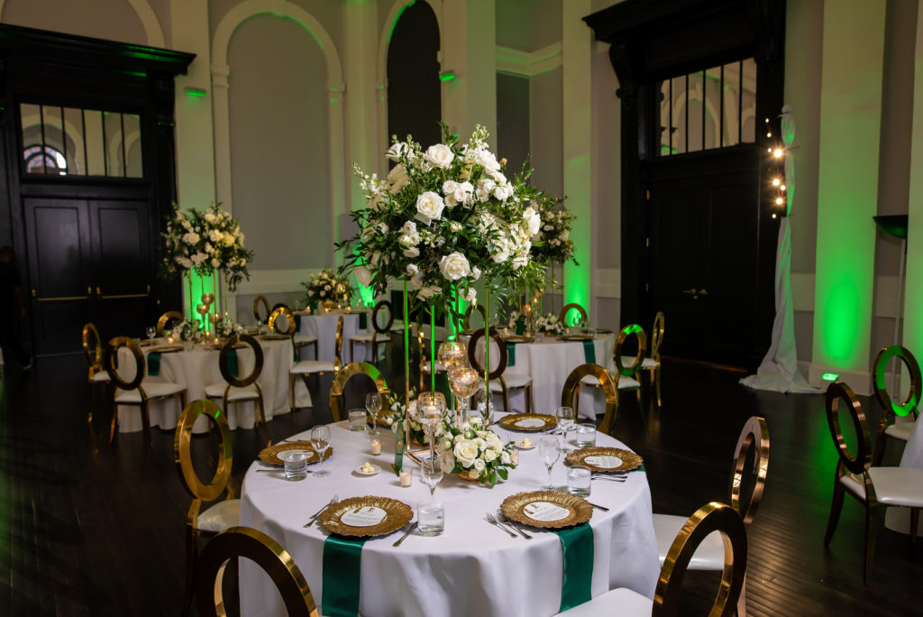 Tall wedding centerpiece with white flowers and greenery