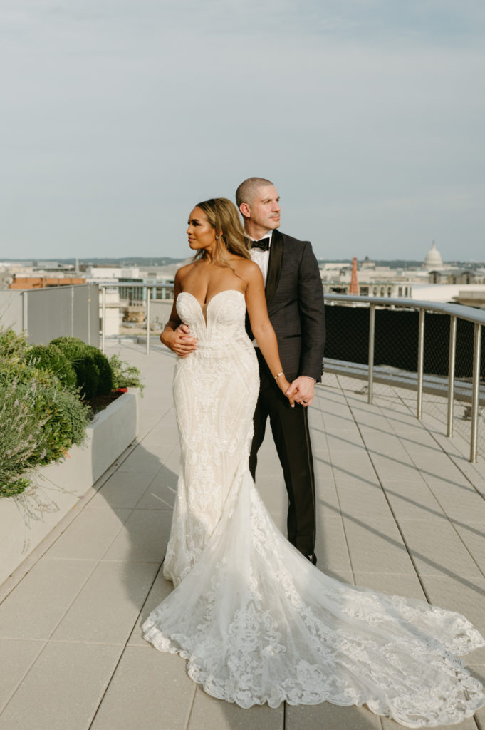 The bride and groom posing on a rooftop
