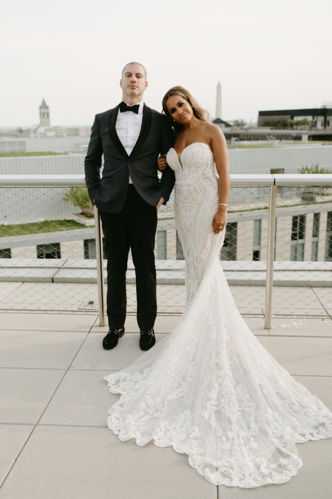 The bride and groom posing for photos on a rooftop wedding venue