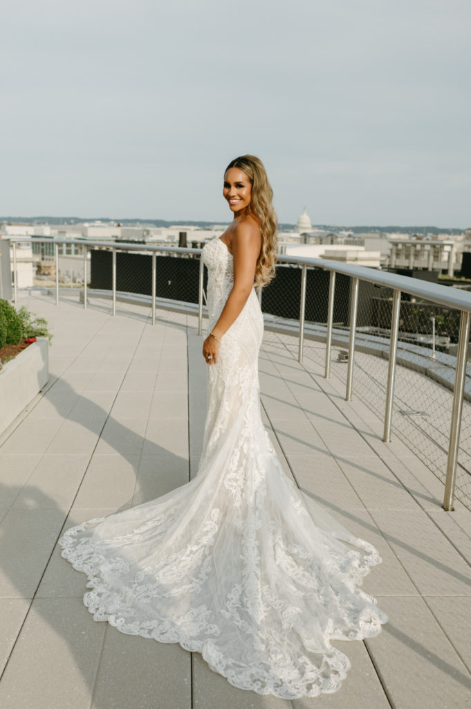 Outdoor portrait of the bride with the train of her lace gown on display