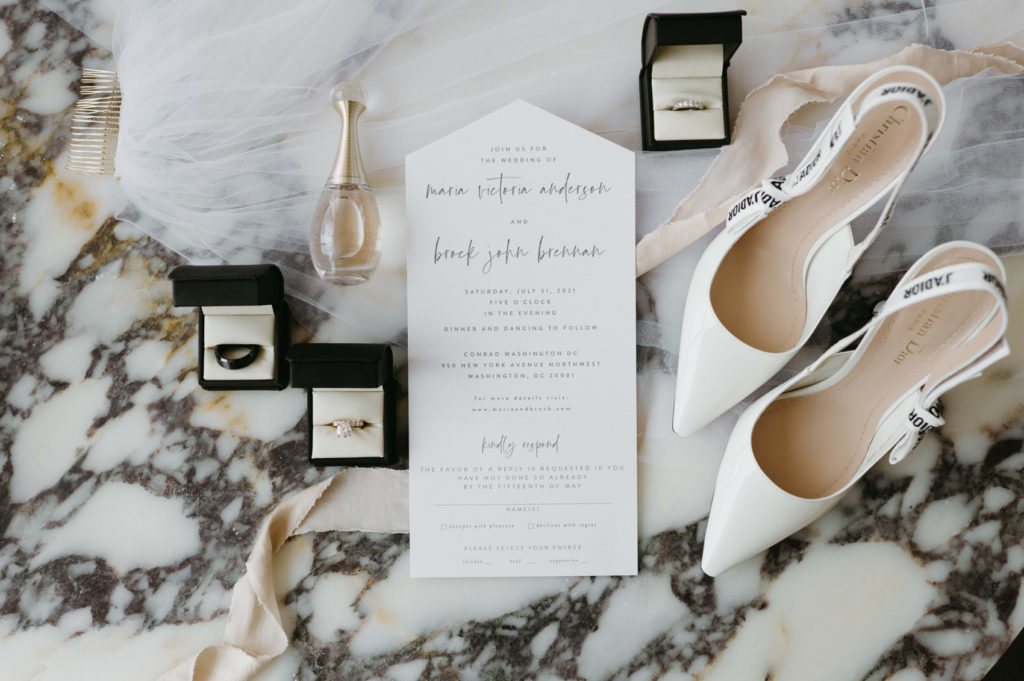 Wedding invitation with bridal shoes, perfume and wedding rings
