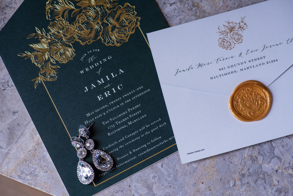Emerald Green and gold wedding invitation with dangling diamond earrings and a gold wax seal