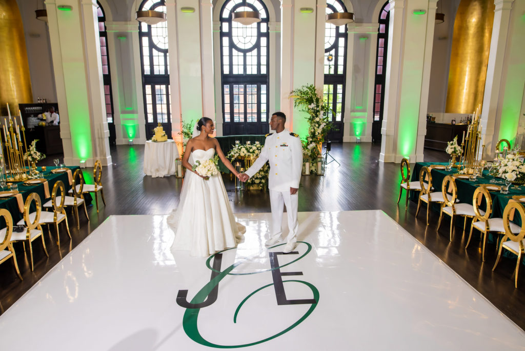 Bride and groom standing on a white, monogrammed dance floor