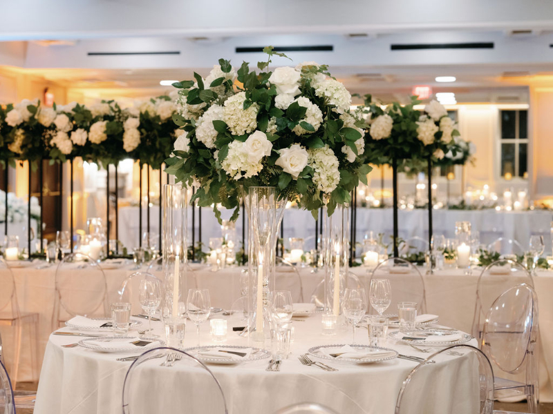 wedding reception decor with tall white and greenery centerpieces