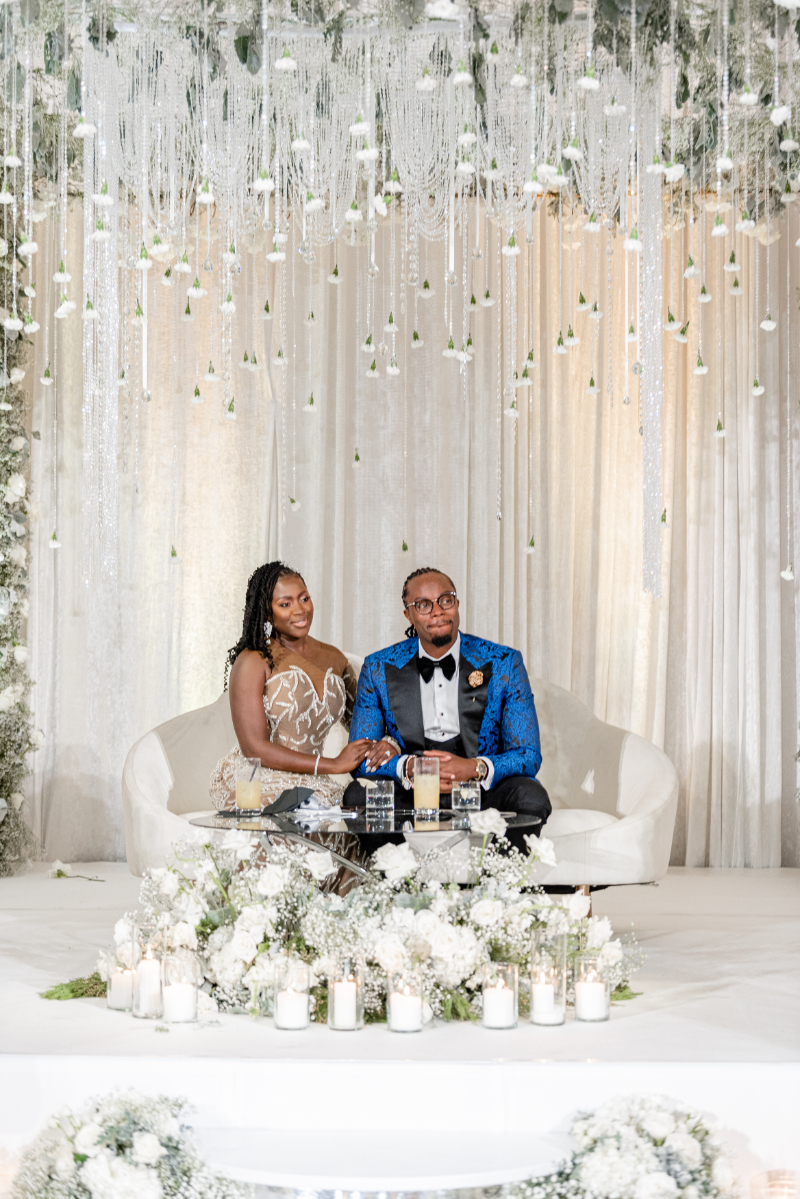 bride and groom sitting at sweetheart table