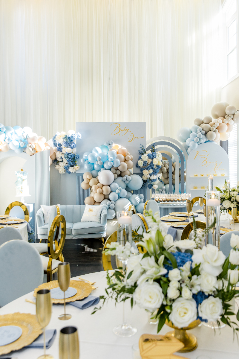 luxury baby boy baby shower decor with balloons, flowers, rainbow arch, gold champagne flutes 