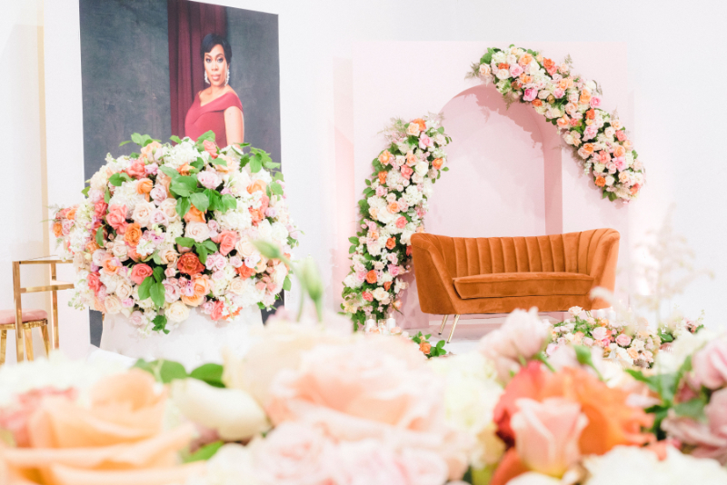 orange velvet couch and abundance of florals for girl baby shower decor