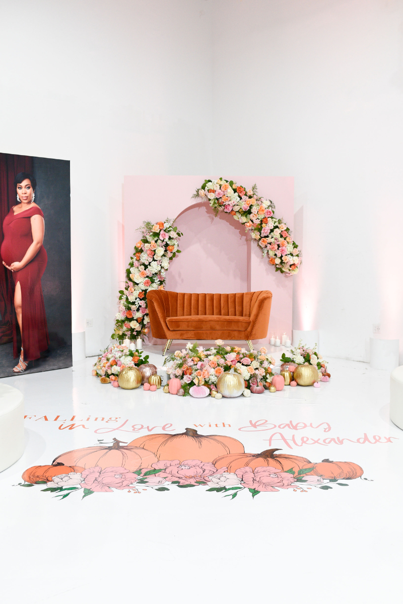 orange velvet couch and abundance of florals for girl baby shower decor