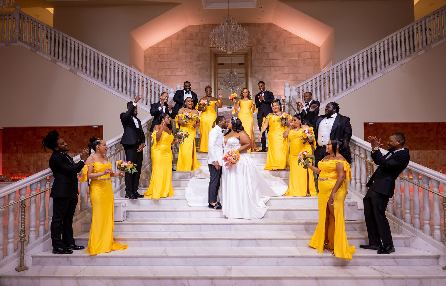 bride and groom and wedding party pose on staircase