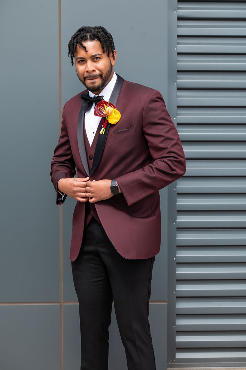 groom in burgundy suit and yellow floral boutonnière 