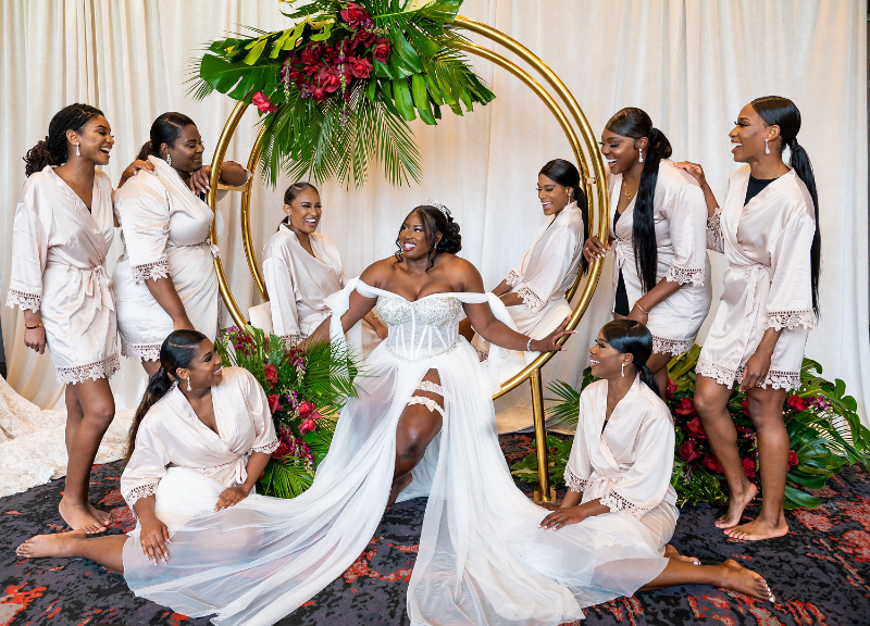 bride sits surrounded by wedding party