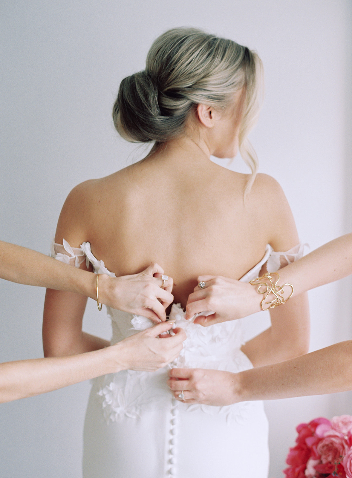 BRIDESMAIDS HELPING WITH BRIDES DRESS