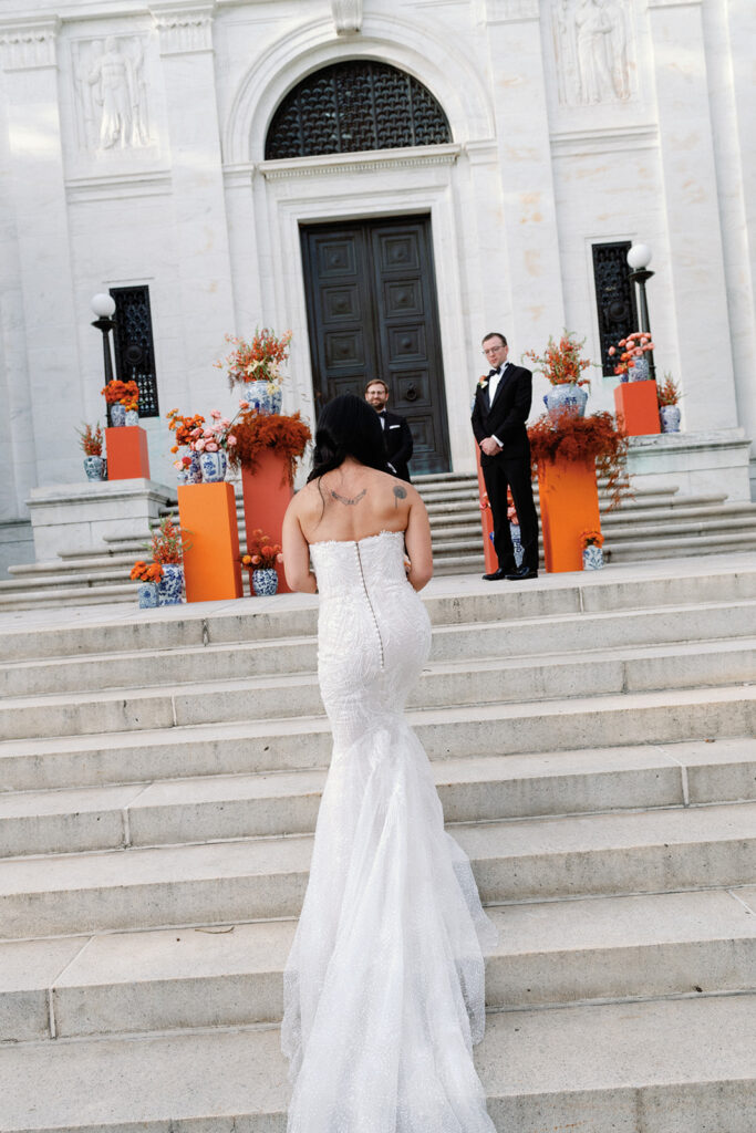 Bride walks down aisle toward her groom at the end of the aisle during this  Potomac View Terrace wedding.