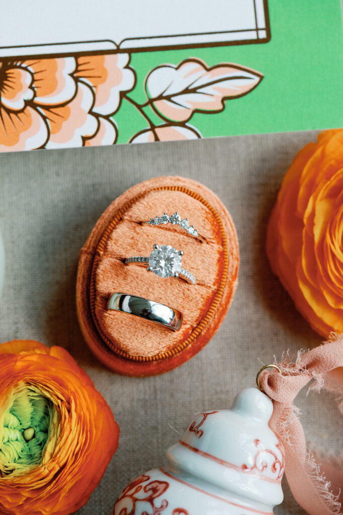 Detail shot of wedding bands surrounded by colorful wedding details.