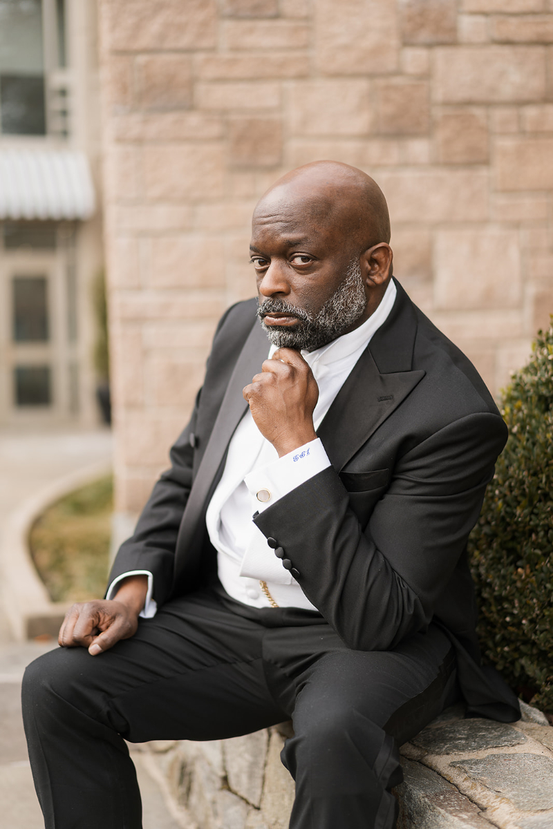 Groom sits for portrait outside Cosmos Club.