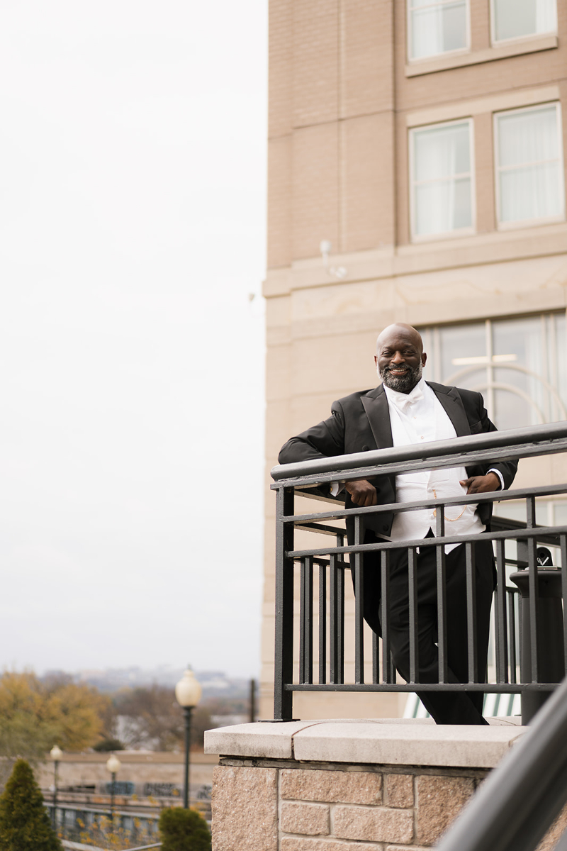 Groom poses for portrait outside Cosmos Club.