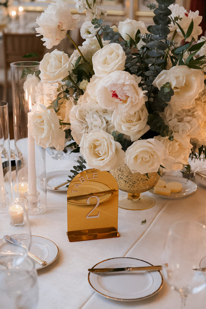 Elevated table settings with lush florals and gold details for Cosmos Club wedding.
