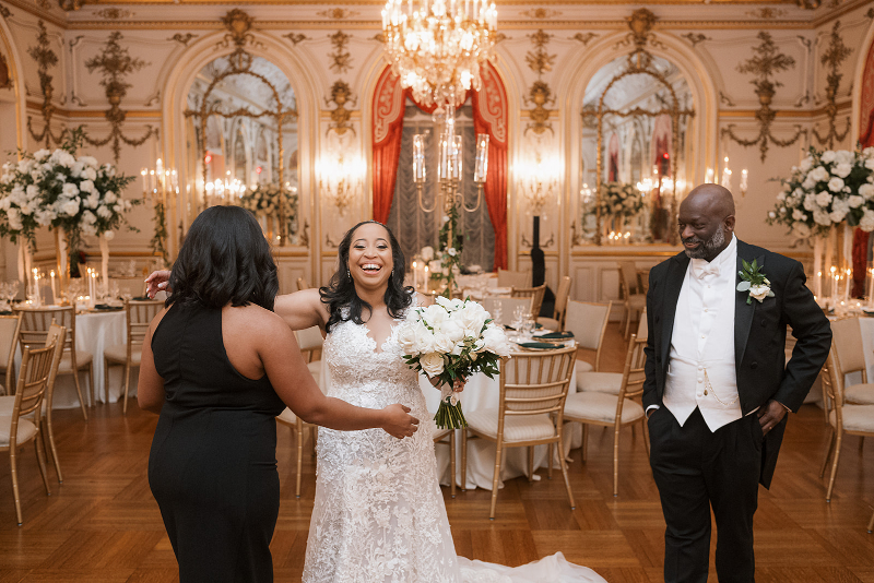 Bride hugs wedding planner, Jayne Heir Events, after reception room reveal for Cosmos Club wedding.