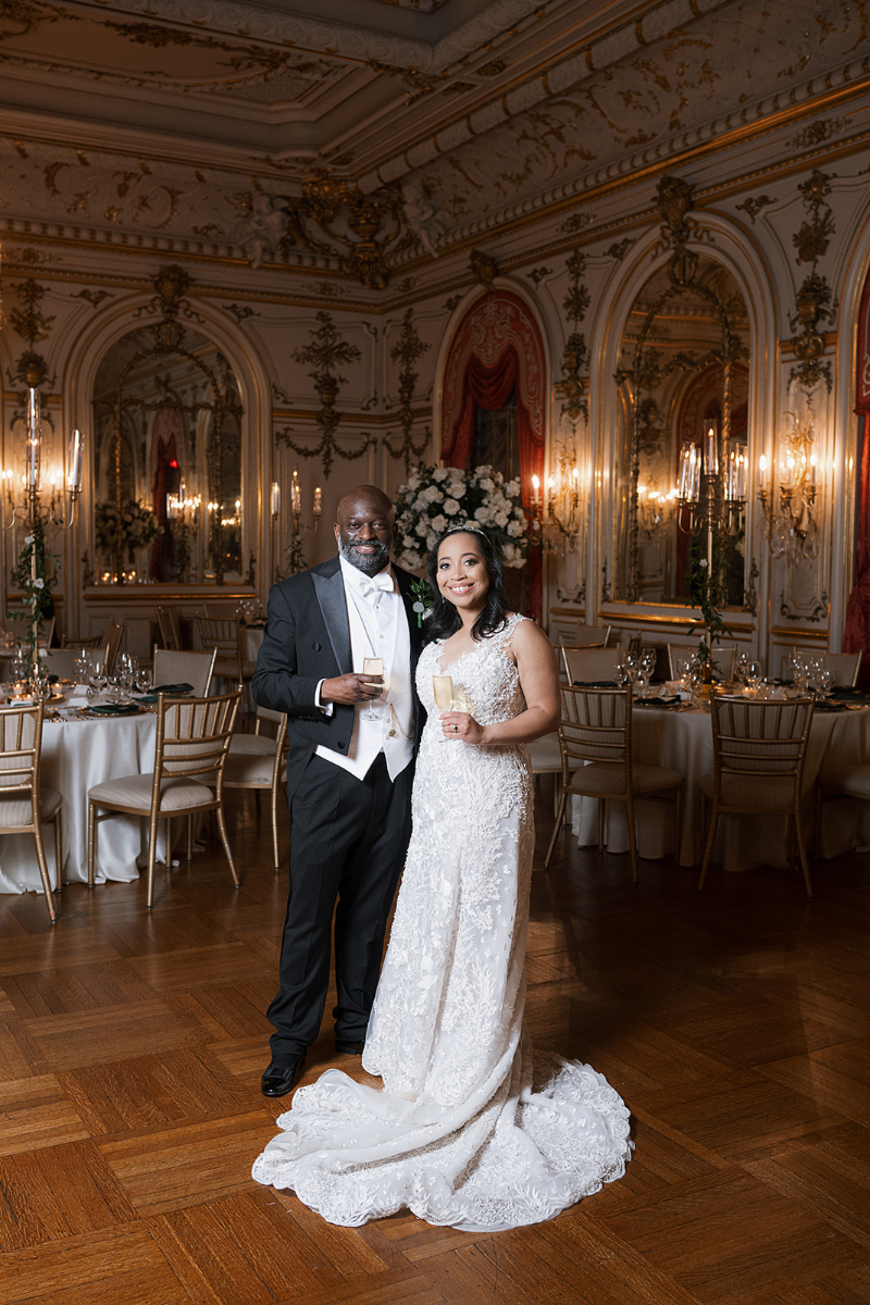Bride and groom pose for photos after their reception room reveal.