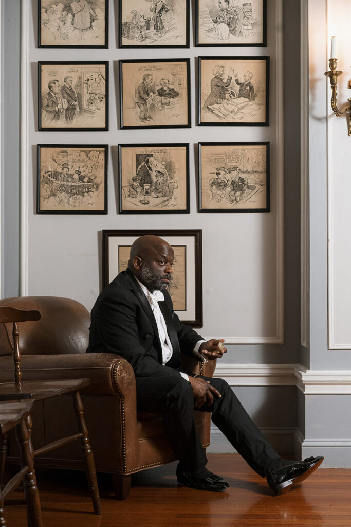 Groom sits or portrait during Cosmos Club wedding.