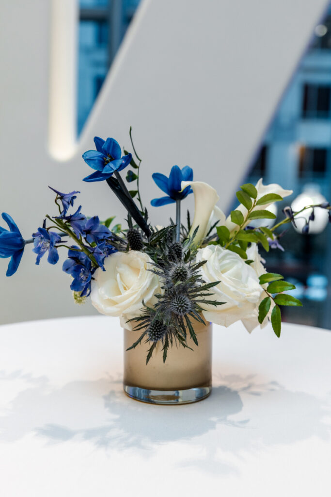 Small vase of blue and white floral arrangement. 