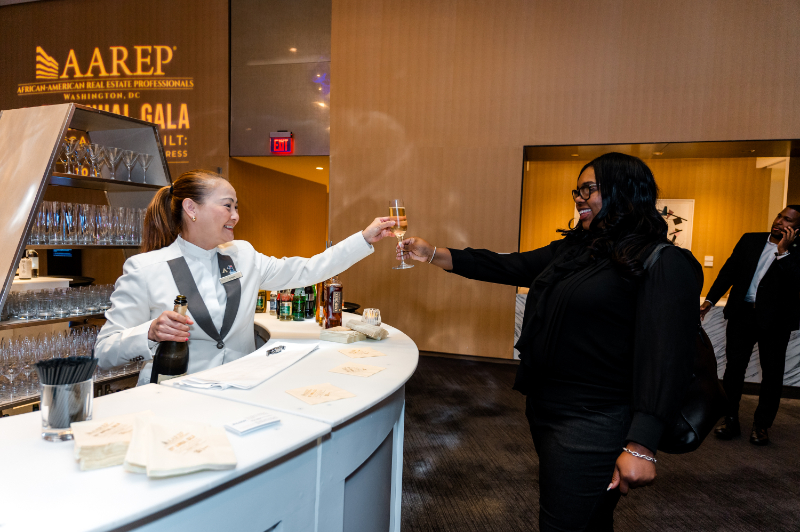Bartender hands guest a drink during the AAREP gala.
