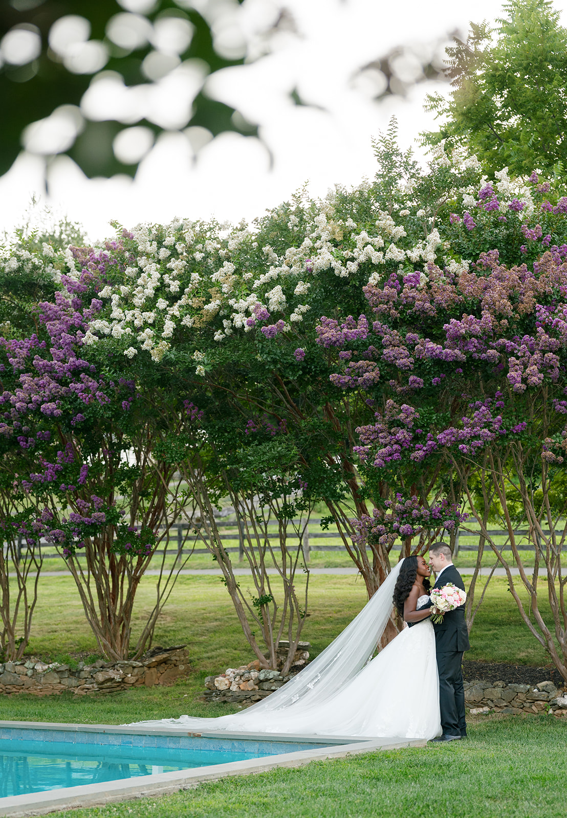 Bride and groom share kiss by the pool at The View of Bluemont during their mansion wedding portraits.