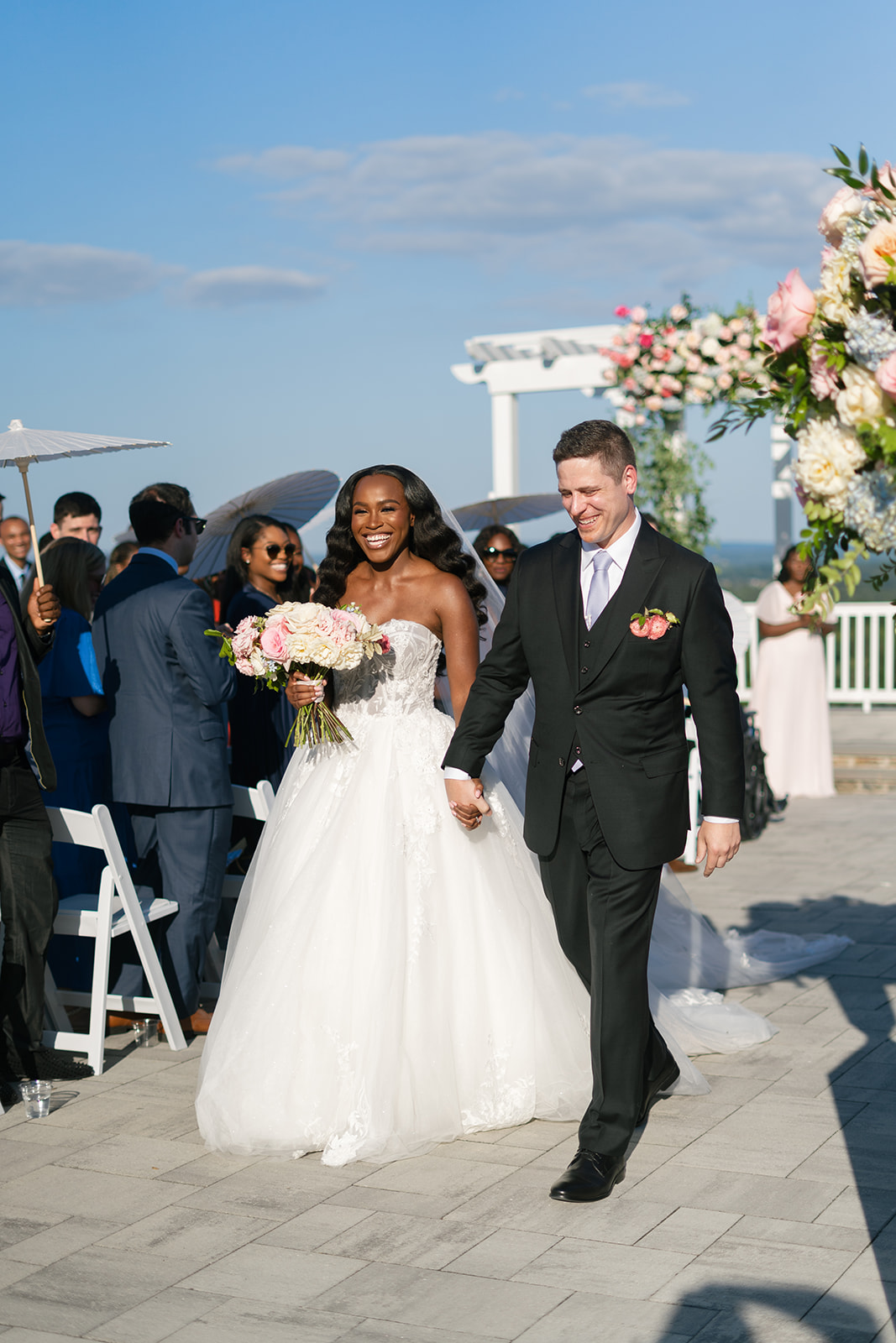 Bride and groom walk hand in hand down ceremony aisle after exchanging vows.