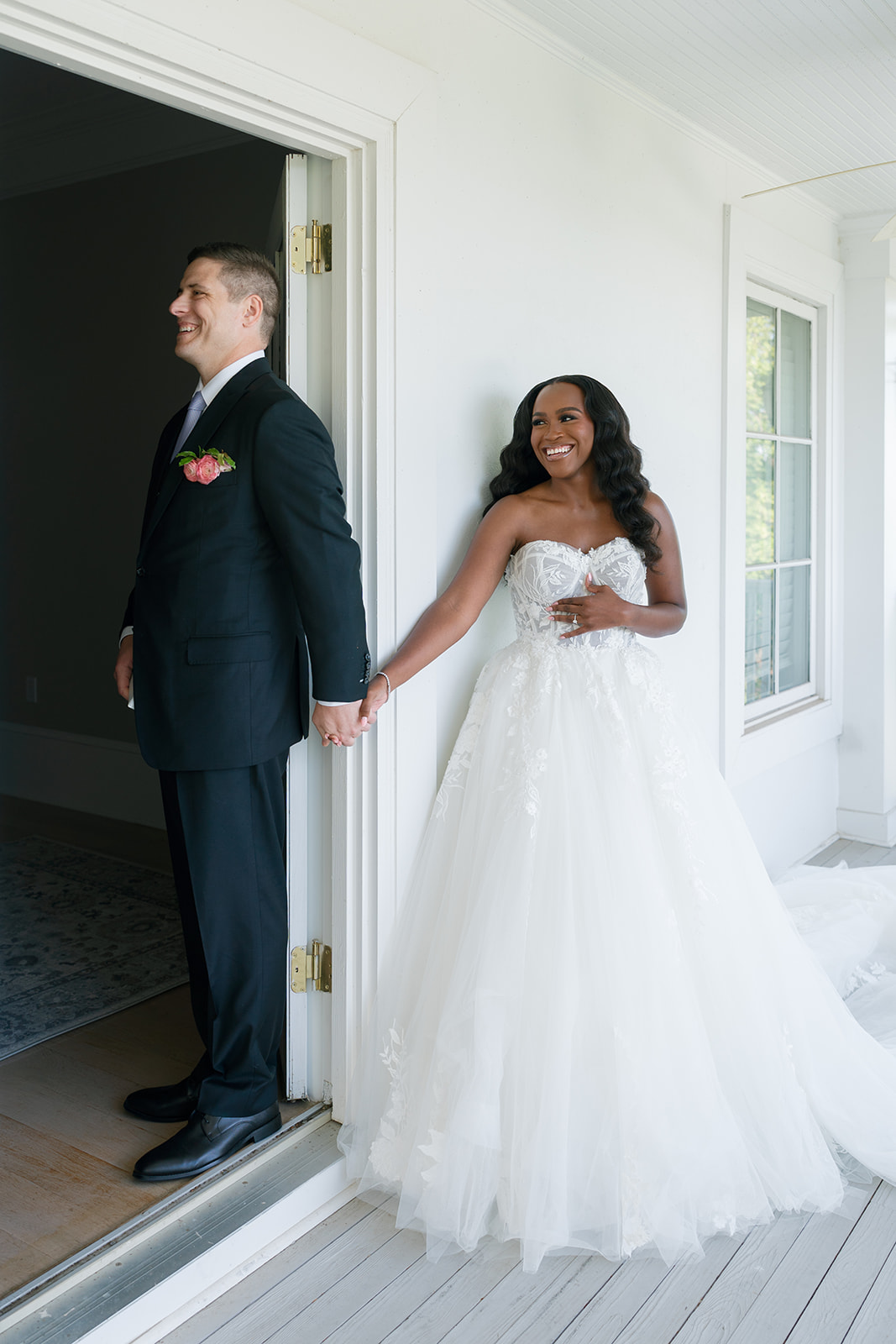 Bride and groom stand together holding hands for their first touch before their wedding ceremony.