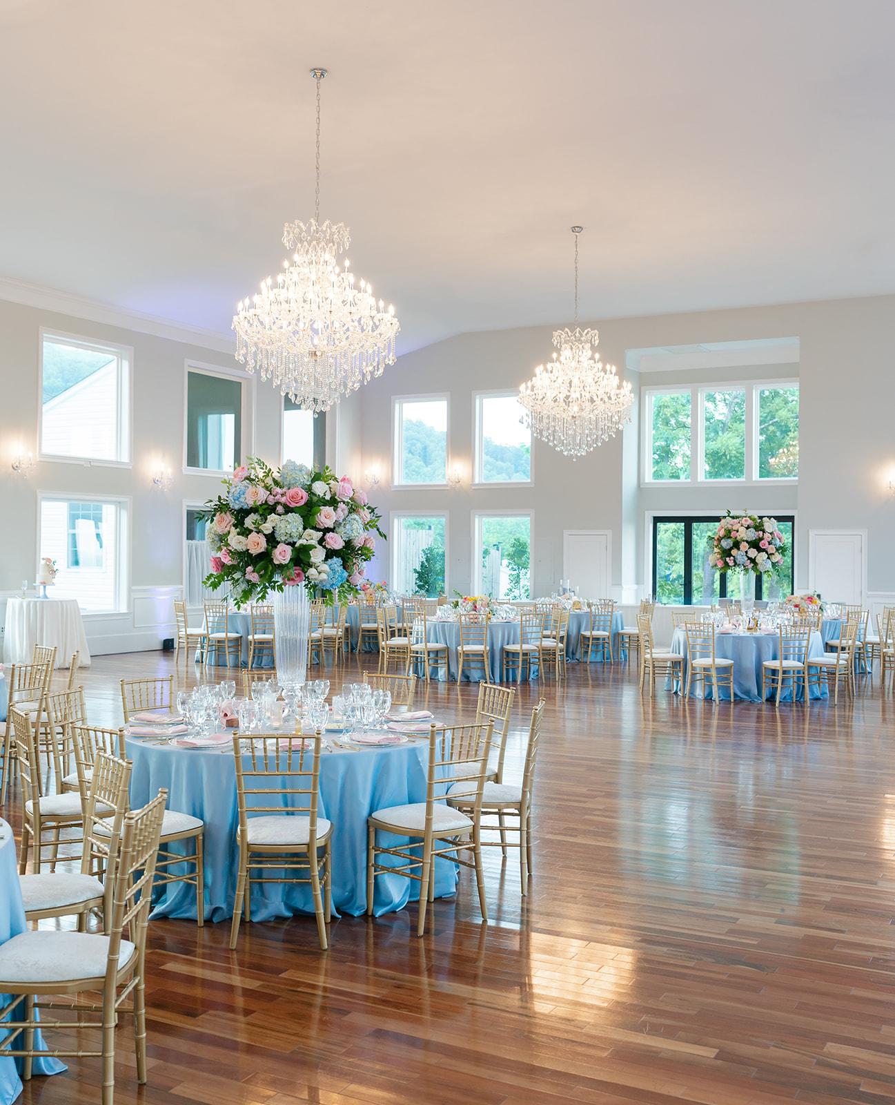 The View of Bluemont decorated for mansion wedding reception with soft blue linens and colorful floral arrangements.
