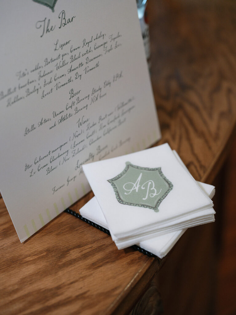 Custom bar menu and monogrammed cocktail napkins displayed during the reception at a historic library wedding venue.
