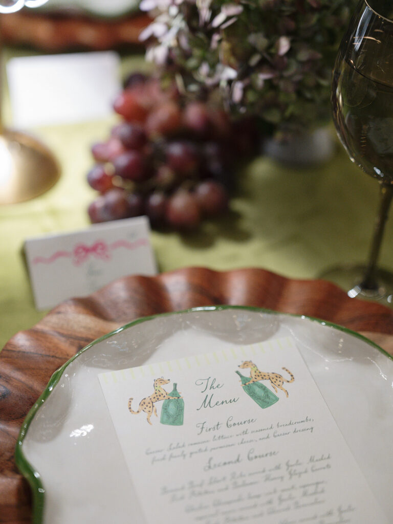 Custom illustrated wedding menu displayed on a scalloped plate with hand-painted leopard details and elegant tablescape.